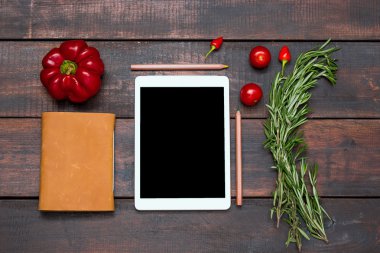 Tablet, defter, taze acı ve tatlı biber ahşap masa arka plan üzerinde