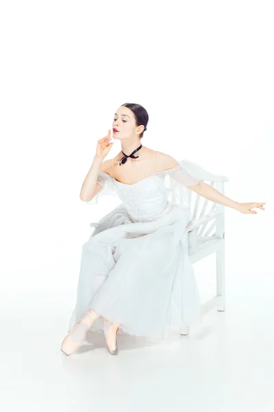 Balerina fehér ruhában ülő, stúdió-háttér. — Stock Fotó