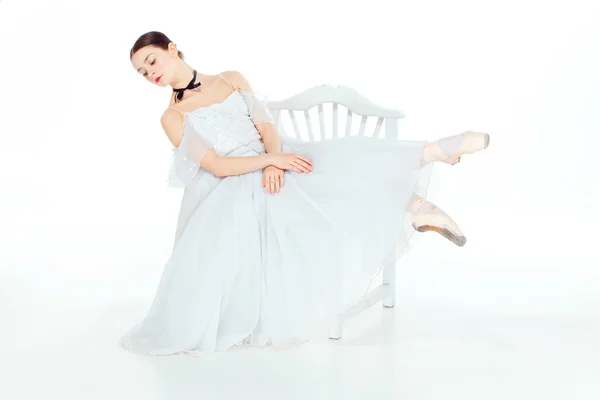 Балерина в Білій сукні сидять, тло студії. — стокове фото