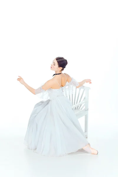 Baletka v bílých šatech sedící, studio pozadí. — Stock fotografie