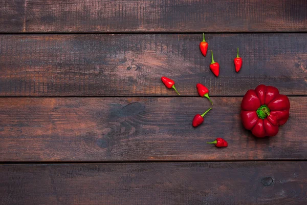 Φρέσκο πικρή και γλυκιά πιπεριά σε φόντο ξύλινο τραπέζι — Φωτογραφία Αρχείου
