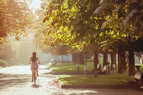 Молодая девушка с велосипедом в парке — стоковое фото