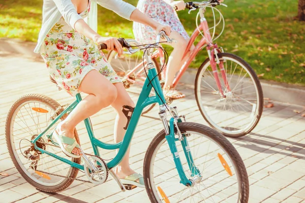 De twee jonge meisjes met fietsen in park — Stockfoto