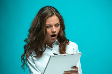 Sürpriz genç iş kadını ile kalem ve tabla için mavi arka plan ile ilgili notlar