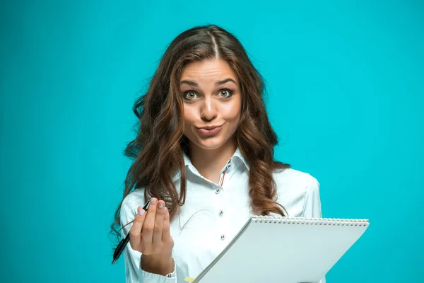 Sorpresa giovane donna d'affari con penna e tablet per note su sfondo blu — Foto Stock