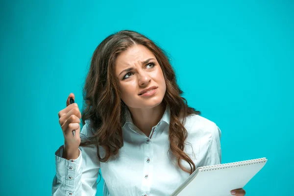 La giovane donna d'affari scontenta con penna e tablet per note su sfondo blu — Foto Stock
