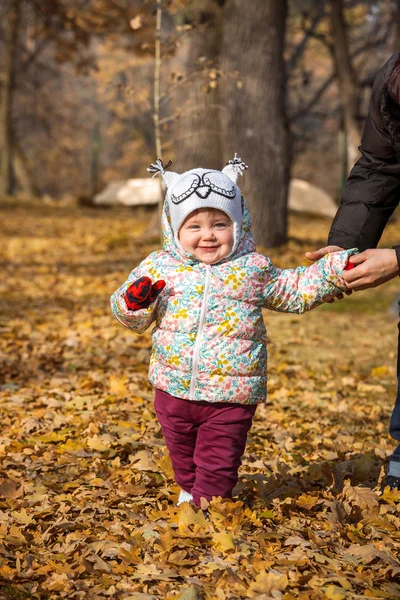 Маленькая девочка, стоящая в осенних листьях — стоковое фото