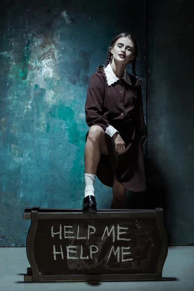 Retrato de uma jovem menina sorridente em uniforme escolar como mulher assassina — Fotografia de Stock
