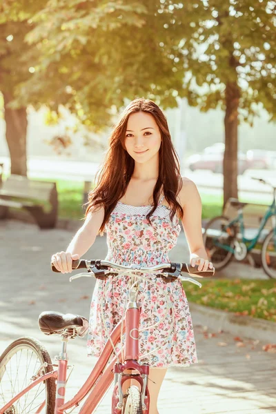 A menina com bicicleta no parque — Fotografia de Stock