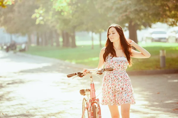 Het jonge meisje met fiets in park — Stockfoto