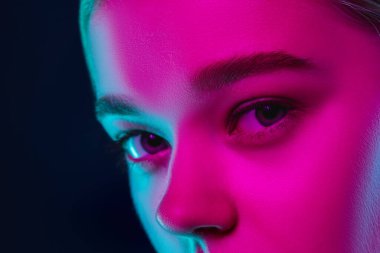 Karanlık stüdyo arka planında neon ışıklı kadın model portresi..