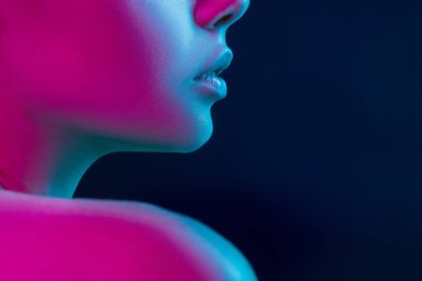 Karanlık stüdyo arka planında neon ışıklı kadın model portresi..