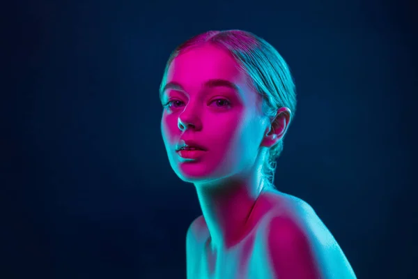 Portrait of female fashion model in neon light on dark studio background. — Stock Photo, Image