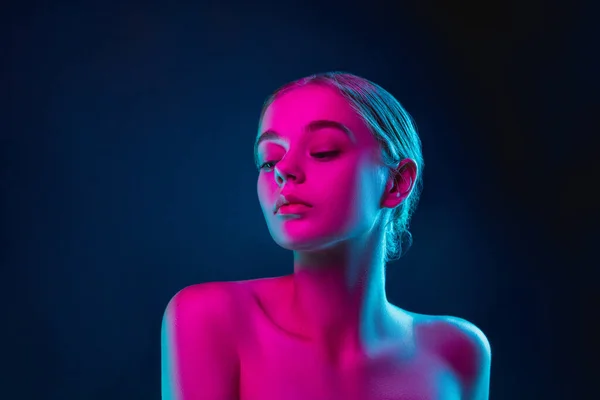 Portrait of female fashion model in neon light on dark studio background. — Stock Photo, Image