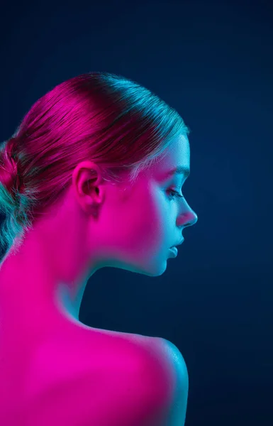 Portret van vrouwelijke mode model in neon licht op donkere studio achtergrond. — Stockfoto