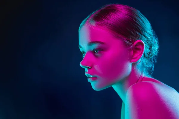 Portrait of female fashion model in neon light on dark studio background. — Stock Photo, Image