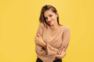 Sarı stüdyo arka planında izole edilmiş parlak duyguları olan beyaz kadın portresi.