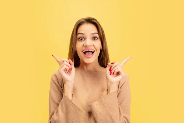 Portret van jonge blanke vrouw met heldere emoties geïsoleerd op gele studio achtergrond — Stockfoto