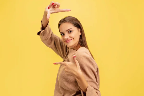 Portræt af ung kaukasisk kvinde med lyse følelser isoleret på gul studiebaggrund - Stock-foto