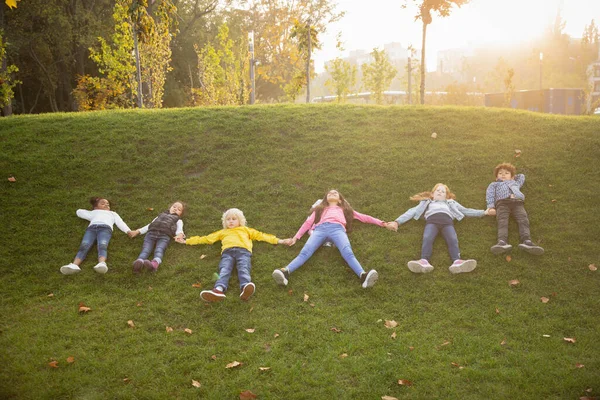 Interraciale groep kinderen, meisjes en jongens spelen samen in het park in de zomer dag — Stockfoto