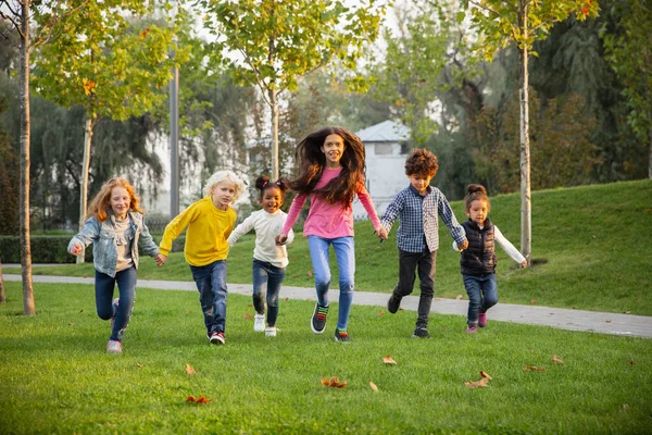 Groupe interracial d'enfants, de filles et de garçons jouant ensemble au parc pendant la journée d'été — Photo