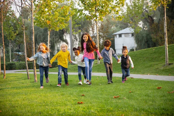 Interracial grupo de crianças, meninas e meninos brincando juntos no parque no dia de verão — Fotografia de Stock