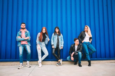 Jeanse kıyafetli dört farklı genç arkadaştan oluşan bir grup tasasız, genç ve mutlu görünüyor.