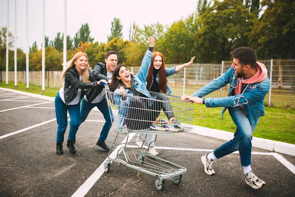 Groep van vier jonge diverse vrienden in jeanse outfit kijken zorgeloos, jong en gelukkig in de straten van de stad — Stockfoto