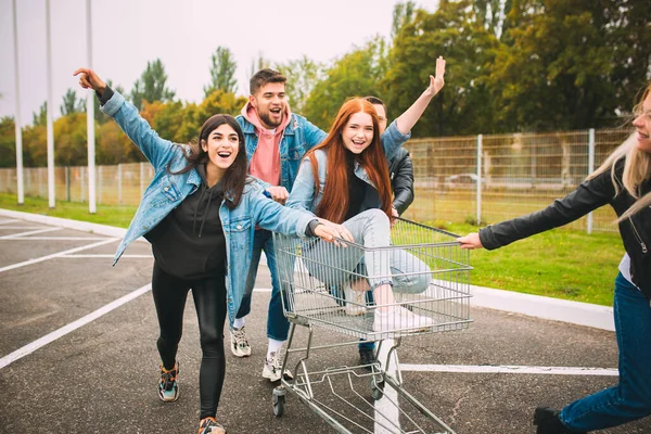 ジーンズ姿の4人の若い多様な友人のグループは、都市の通りで屈託のない、若く、幸せなように見えます — ストック写真