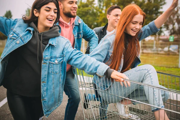 Skupina čtyř mladých různorodých přátel v džínové oblečení vypadají bezstarostně, mladý a šťastný na citys ulicích — Stock fotografie