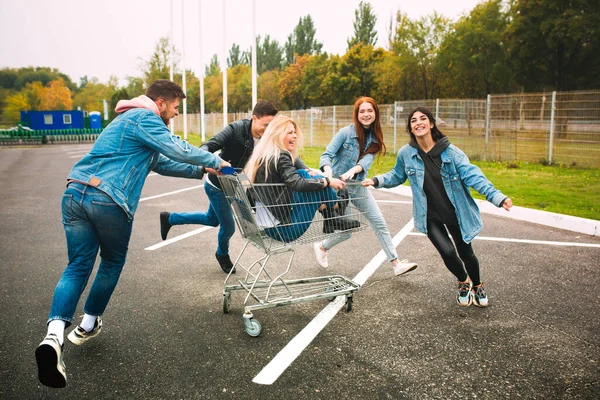 Group of four young diverse friends in jeanse outfit look carefree, young and happy on citys streets — Stock Photo, Image