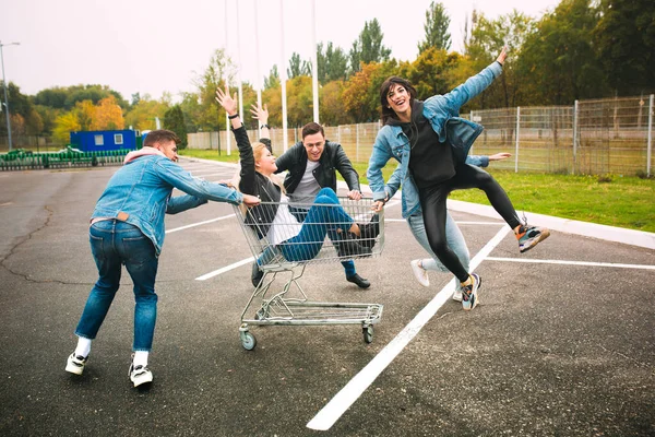 Group of four young diverse friends in jeanse outfit look carefree, young and happy on citys streets — Stock Photo, Image