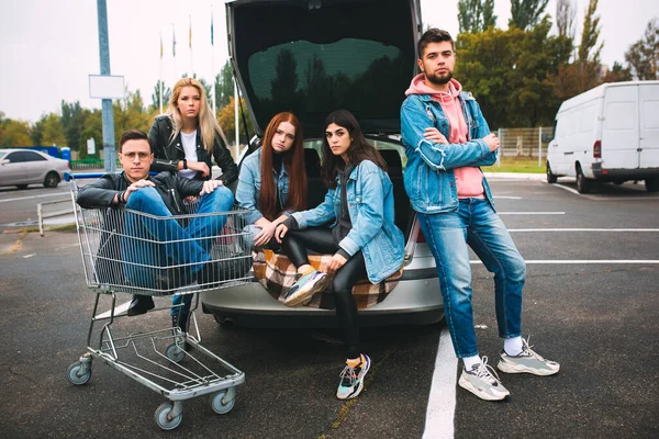 Grupo de cuatro jóvenes y diversos amigos en traje jeanse se ven despreocupados, jóvenes y felices en las calles de la ciudad — Foto de Stock