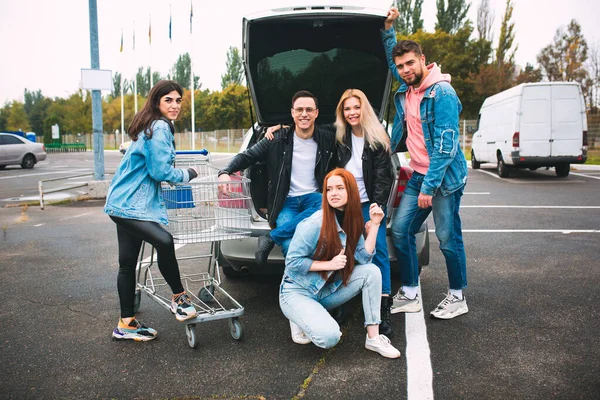 Group of four young diverse friends in jeanse outfit look carefree, young and happy on citys streets