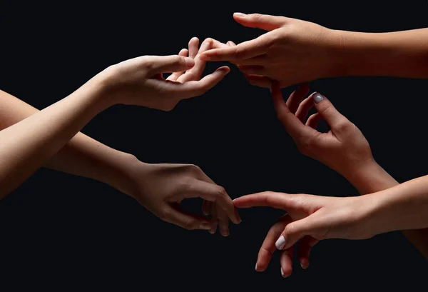 Mãos de pessoas se reúnem em contato isolado no fundo do estúdio preto. Conceito de relação humana, comunidade, união, simbolismo — Fotografia de Stock