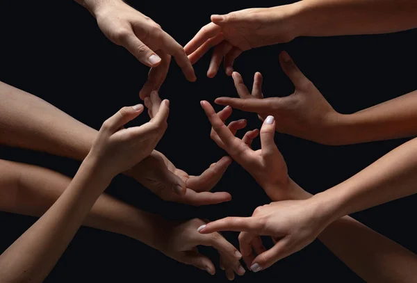 Hände von Menschen drängen sich isoliert auf schwarzem Studiohintergrund in Berührung. Konzept menschlicher Beziehung, Gemeinschaft, Zusammengehörigkeit, Symbolik — Stockfoto