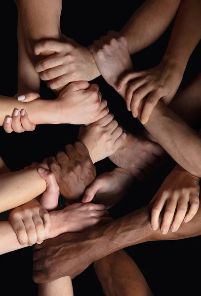 Hands of peoples crowd in touch isolated on black studio background. Concept of human relation, community, togetherness, symbolism