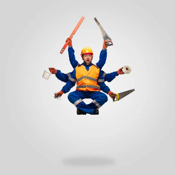 Handsome contractor, multi-armed builder levitating isolated on grey studio background — Stock Photo, Image