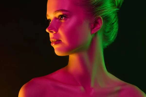 Retrato de modelo de moda feminina em luz de néon no fundo escuro estúdio. — Fotografia de Stock