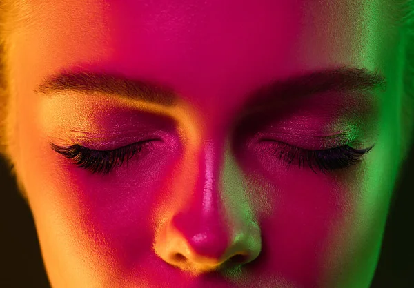Nahaufnahme Porträt eines weiblichen Modells in Neonlicht auf dunklem Studiohintergrund. — Stockfoto