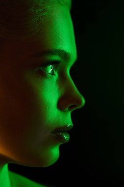 Karanlık stüdyo arka planında neon ışıklı kadın model portresi.