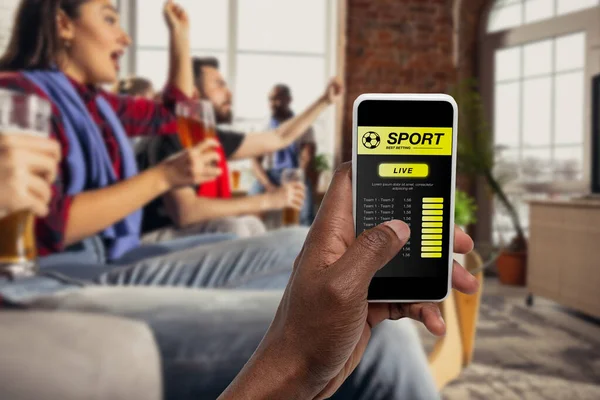 Gerätebildschirm mit mobiler App für Wetten und Tore, jubelnde Freunde, Fans im Hintergrund — Stockfoto