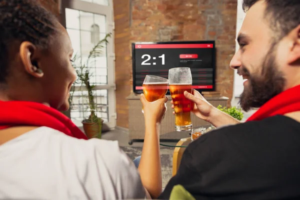 TV screen with mobile app for betting and score, cheering friends, fans in front of it look excited