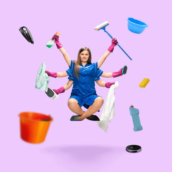 Handsome multi-armed housemaid levitating isolated on pink studio background with equipment — Stock Photo, Image