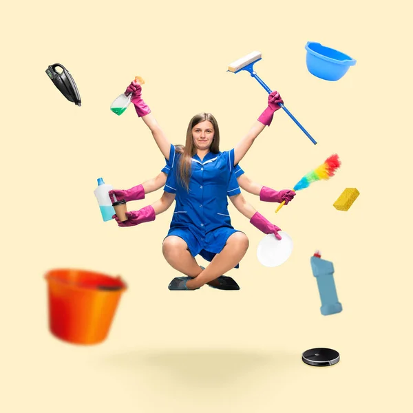 Handsome multi-armed housemaid levitating isolated on yellow studio background with equipment — Stock Photo, Image