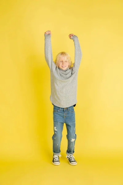 Sarı stüdyo arka planında izole edilmiş parlak duyguları olan beyaz bir çocuğun portresi. — Stok fotoğraf