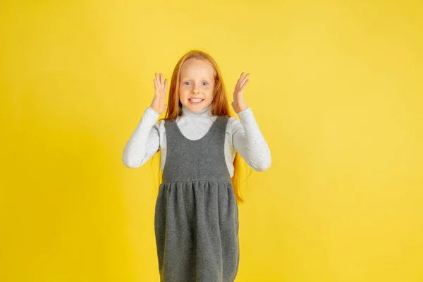 Porträtt av liten kaukasiska flicka med ljusa känslor isolerad på gul studio bakgrund — Stockfoto