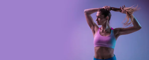 Jovem mulher esportiva treinando isolado no fundo do estúdio gradiente em luz de néon. atlético e gracioso — Fotografia de Stock