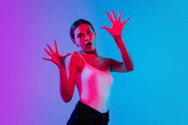 Beyaz kadın portresi, neon ışıklarıyla mavi-mor renkli gradyan stüdyo arka planında.