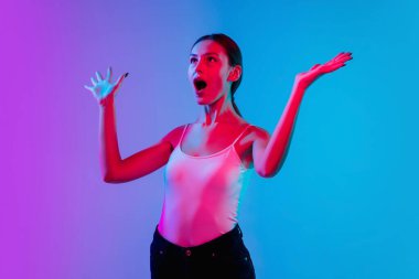 Beyaz kadın portresi, neon ışıklarıyla mavi-mor renkli gradyan stüdyo arka planında.